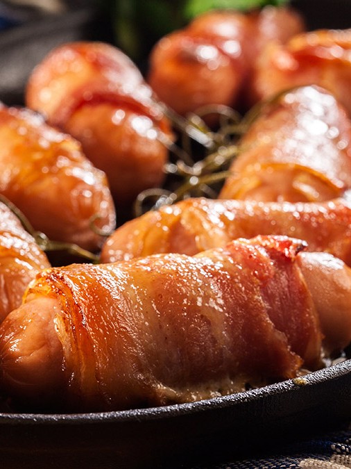 Image of pork sausages wrapped in crispy bacon
